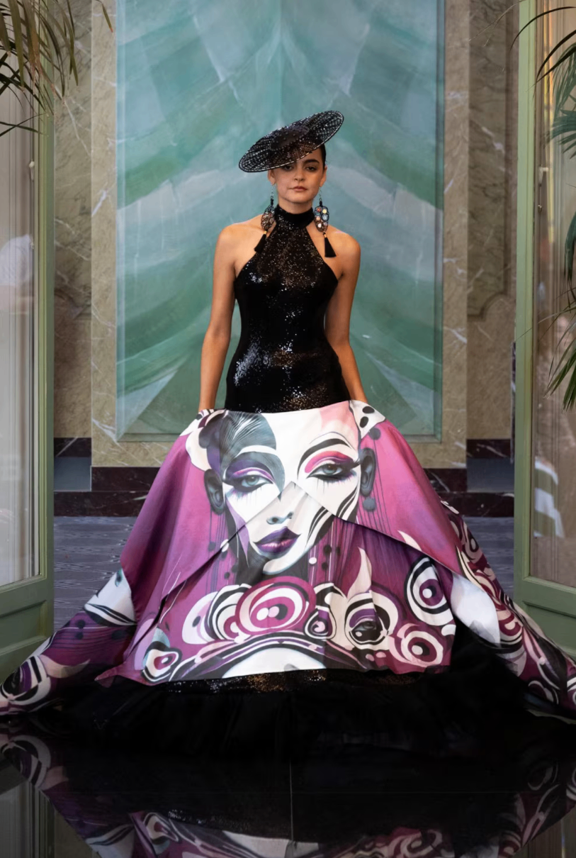 Black sequined halter gown with a magenta overskirt painted with a muse’s face, worn with a crystal headpiece at Paris Fashion Week 2025
